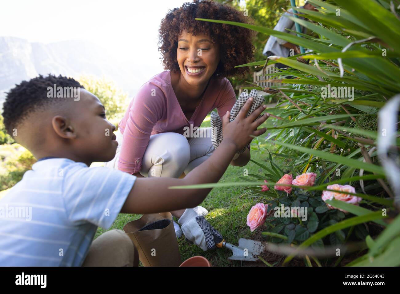 Happy african american mother with son outdoors, gardening on sunny day Stock Photo