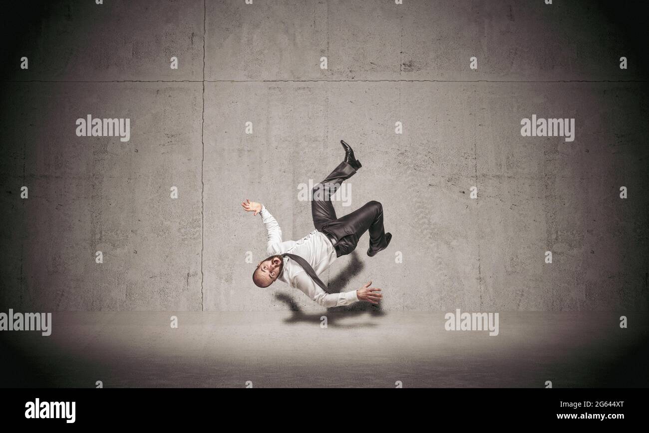 businessman falling on concrete background. Stock Photo