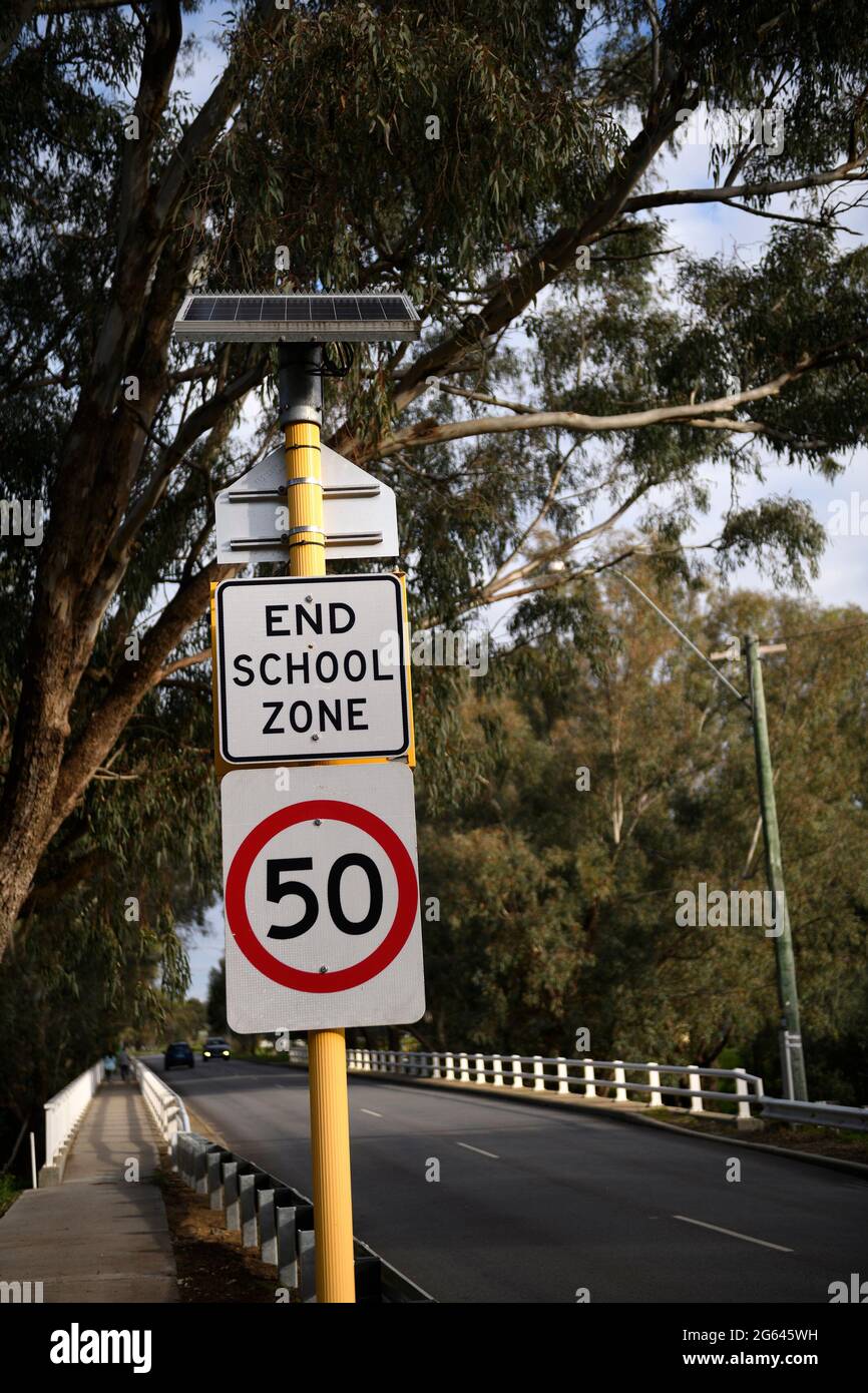 Sign indicating end of School Zone and commencement of speed limit of 50 kilometers per hour. Stock Photo
