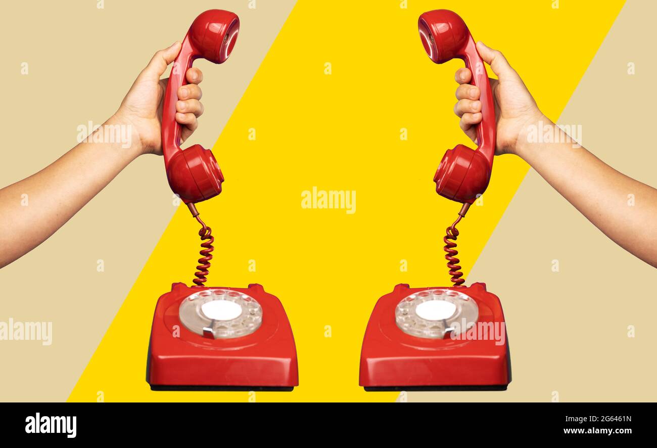 Hand holding the receiver of a retro red telephone Stock Photo