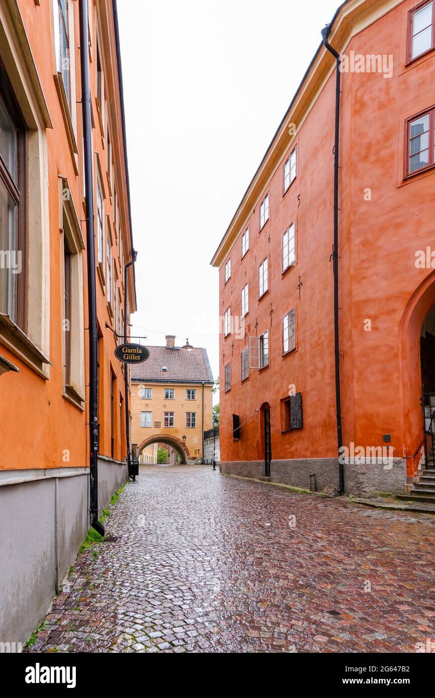 Uppsala, Sweden - 25 June, 2021: empty cobblestone street in the historic city center of Uppsala with red and orange stone buildings Stock Photo