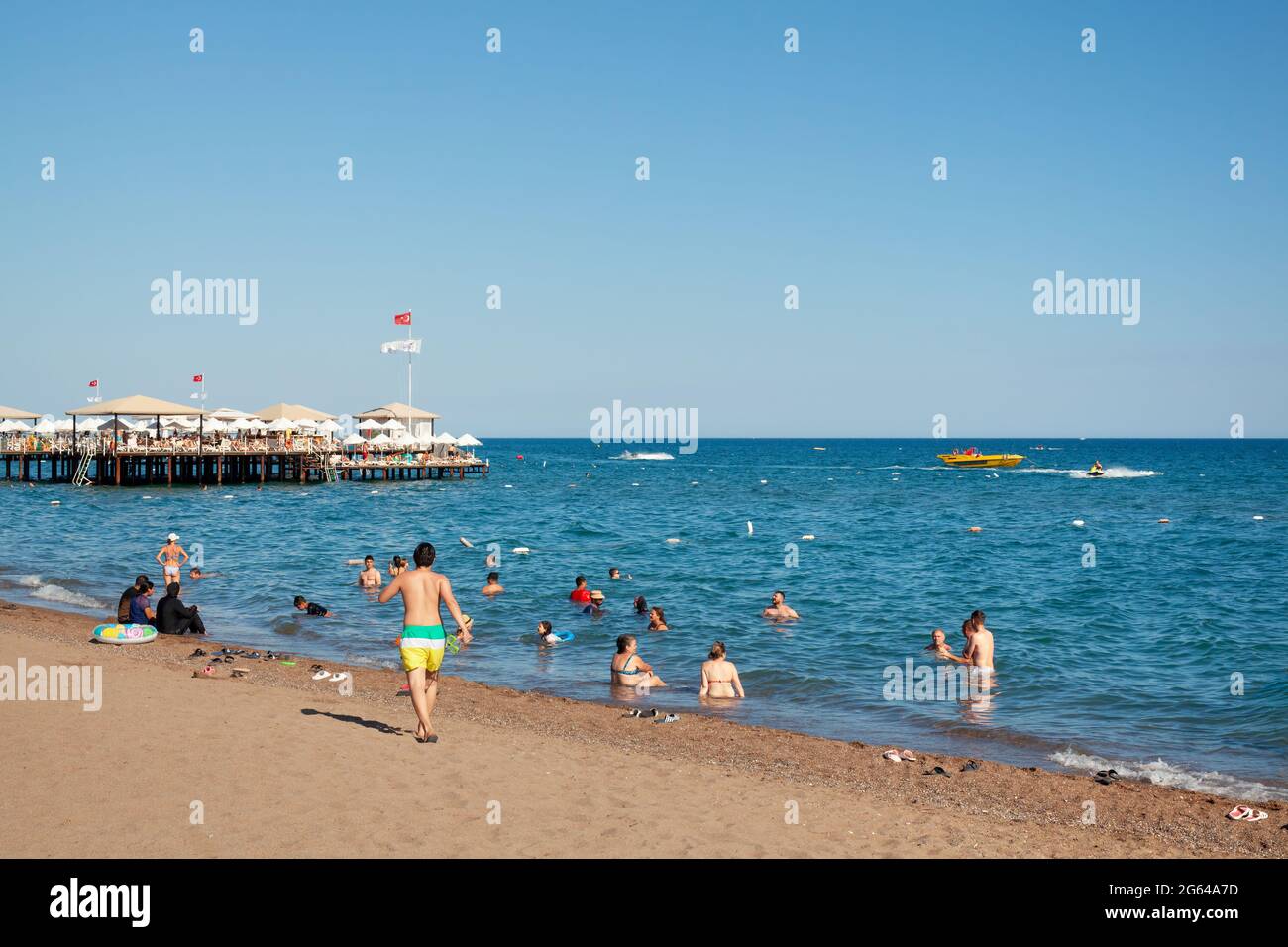 Antalya, Turkey-June 29, 2021: Beach-goers sunbathing, swimming or doing other activities on the beach in summer in Antalya. Stock Photo