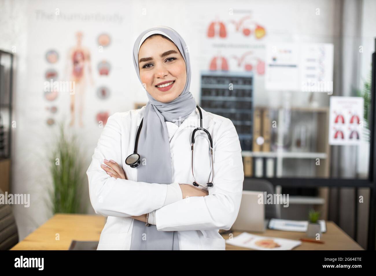 Muslim female doctor in hijab with stethoscope on neck posing at her  private cabinet. Qualified medical worker wearing white lab coat. Concept  of health care Stock Photo - Alamy