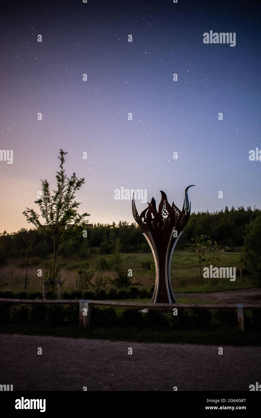 Stars in the night sky on a clear summer's evening behind an artistic statue. Stock Photo
