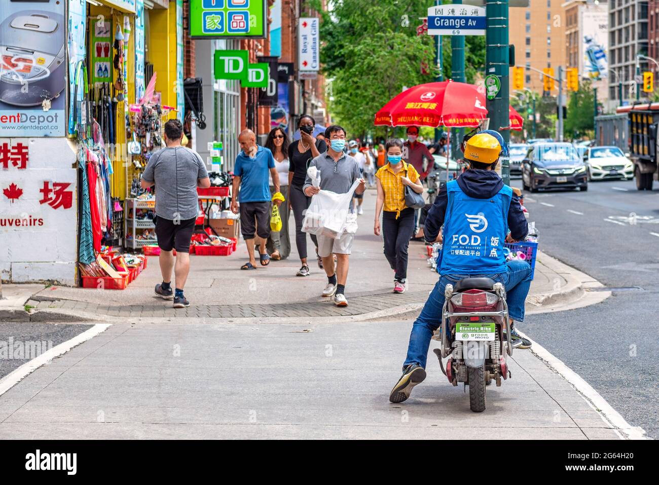Food delivery in electric bike in the Chinatown district, Toronto, Canada Stock Photo