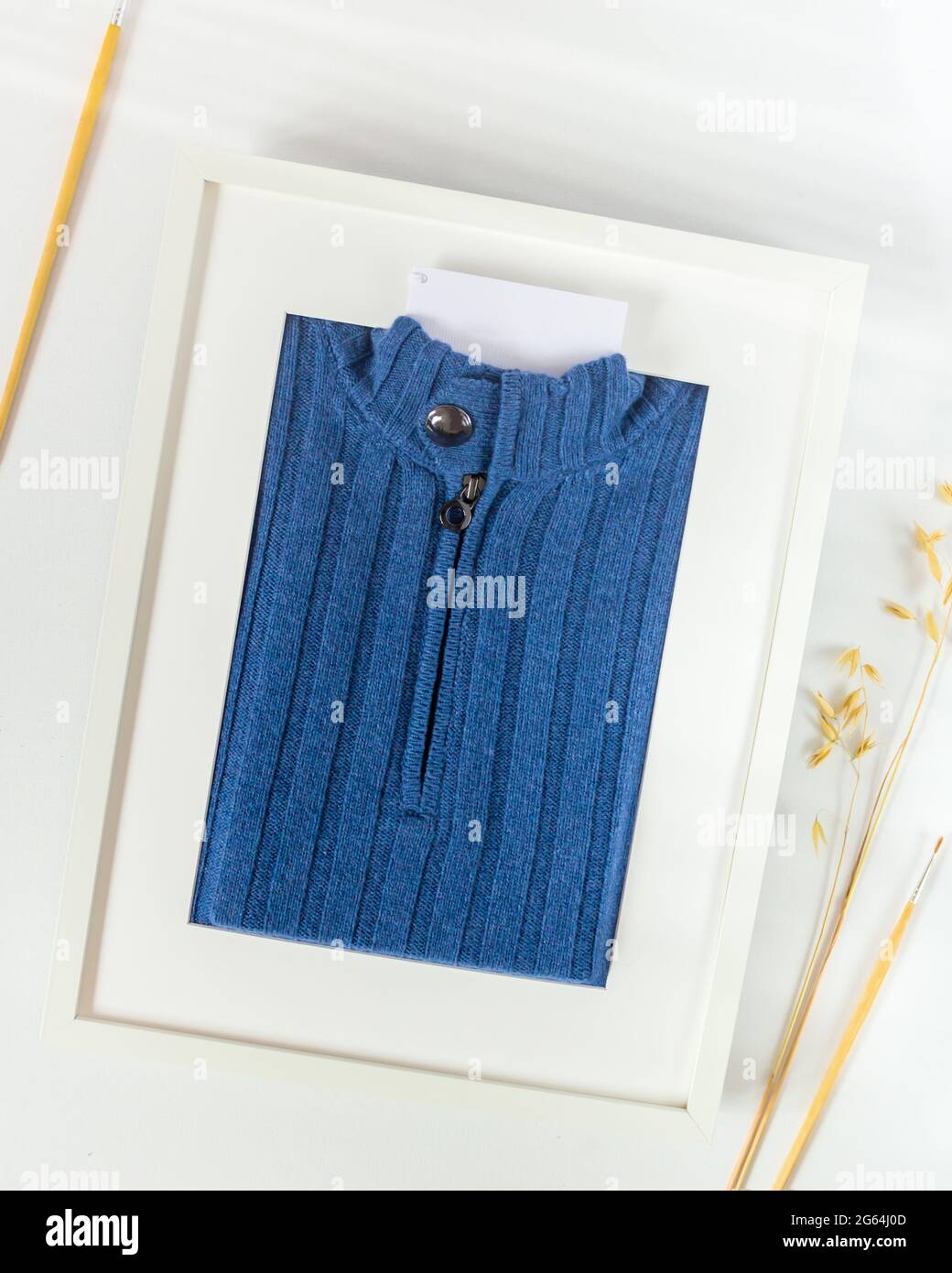 High quality, men's, knitted sweater made of expensive, natural fabric packed like a picture in a frame with a label for your brand. Clothes mockup Stock Photo