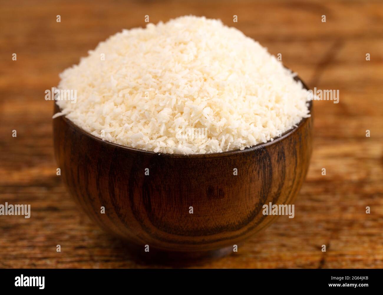 Raw Organic Unsweetened Coconut in a Wooden Bowl Stock Photo