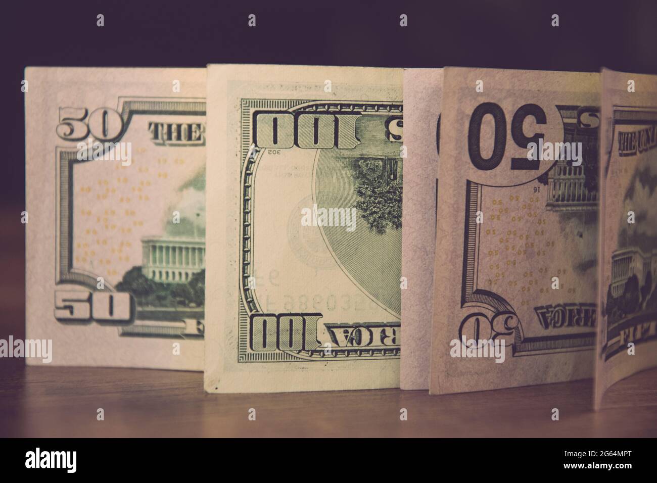 Selective focus of fifty dollar bills and one hundred dollar bills upside down. Details of US currency paper banknotes with figures 50 and 100 Stock Photo