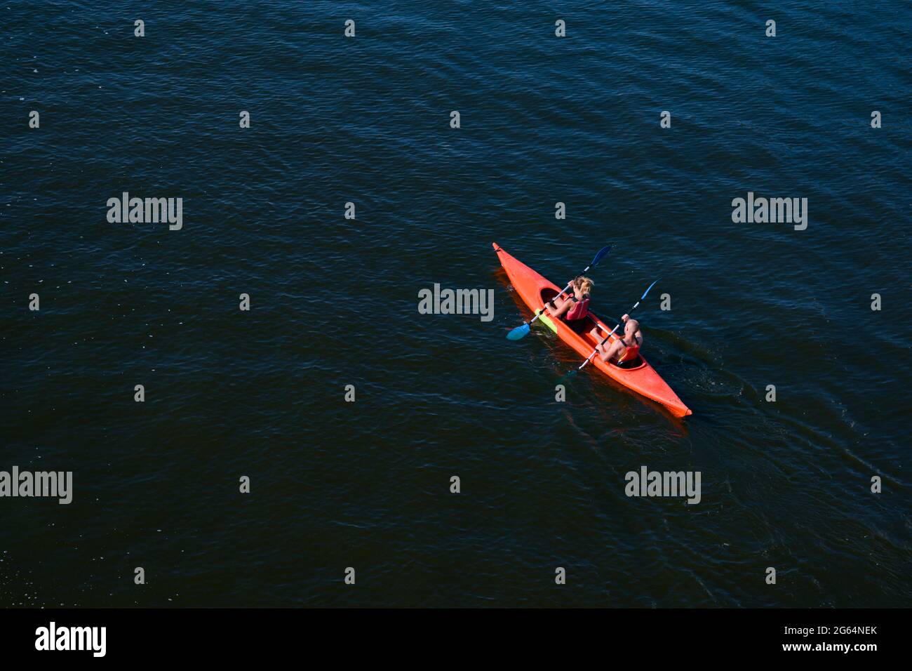 Top view of a man and a woman in a kayak floating on the river. Sports recreation on the water
