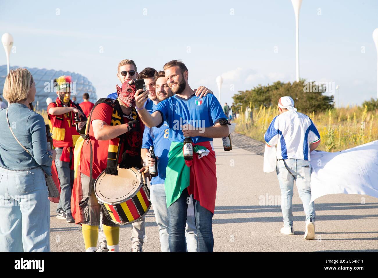 Italienische Fans schießen ein Selfie mit einem belgischen Fan als Teufel. Zum Euro 2020 Spiel Italien gegen Belgien reisen die Fans der beiden Mannschaften am 2. Juli 2021 zur Allianz Arena in München an. Der Sieger wird sich für das Halbfinale qualifizieren. * Italian fans take a selfie with a belgian fan weraing a devil's mask. Fans before the Euro 2020 match between Italy and Belgium in the Allianz Alrena in Munich, Germany on July 2, 2021. (Photo by Alexander Pohl/Sipa USA) Credit: Sipa USA/Alamy Live News Stock Photo