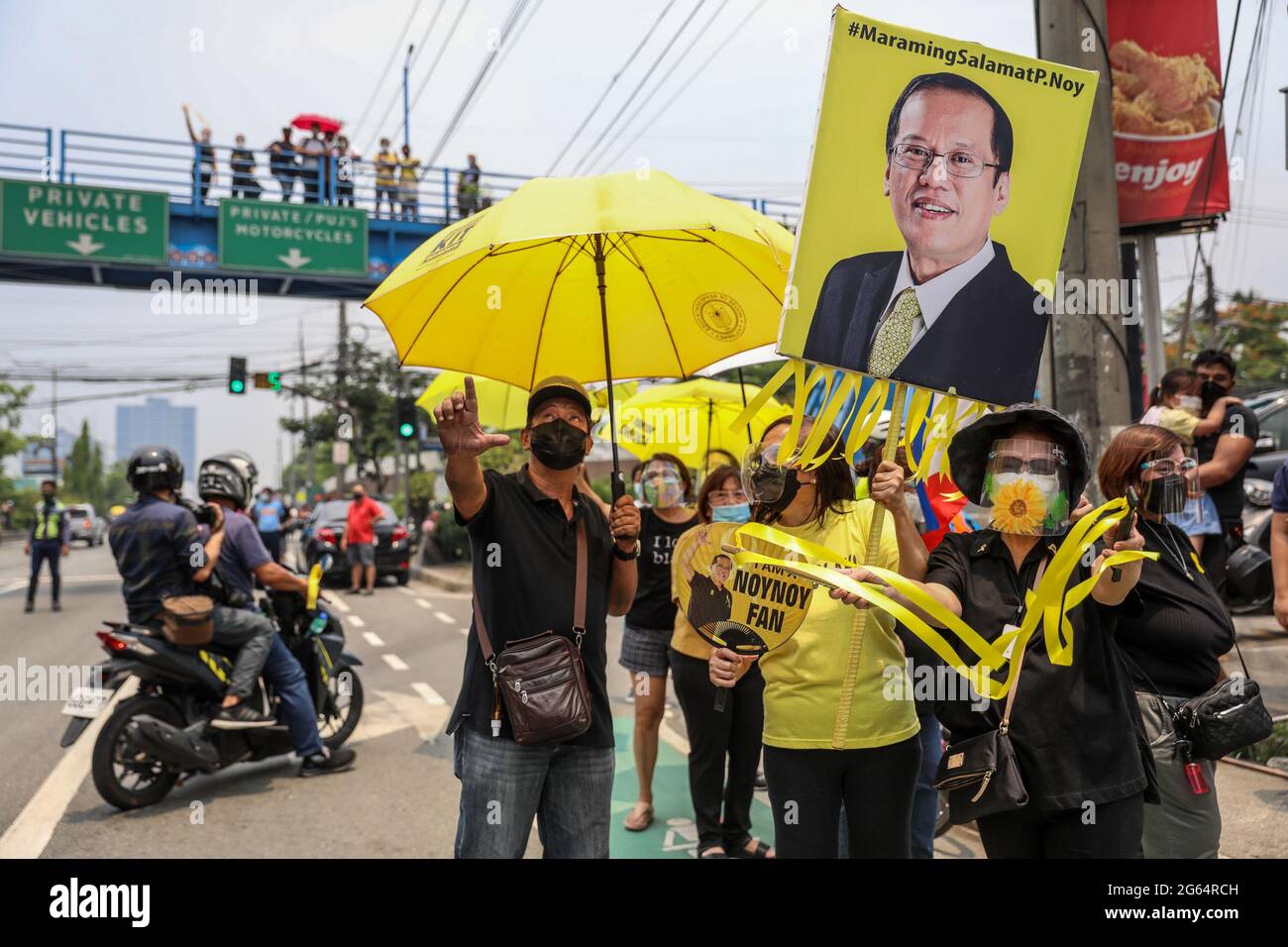 Supporters carry signs as they gather beside the motorcade of former Philippine President Benigno Aquino III before his burial in Quezon City, Philippines. Stock Photo