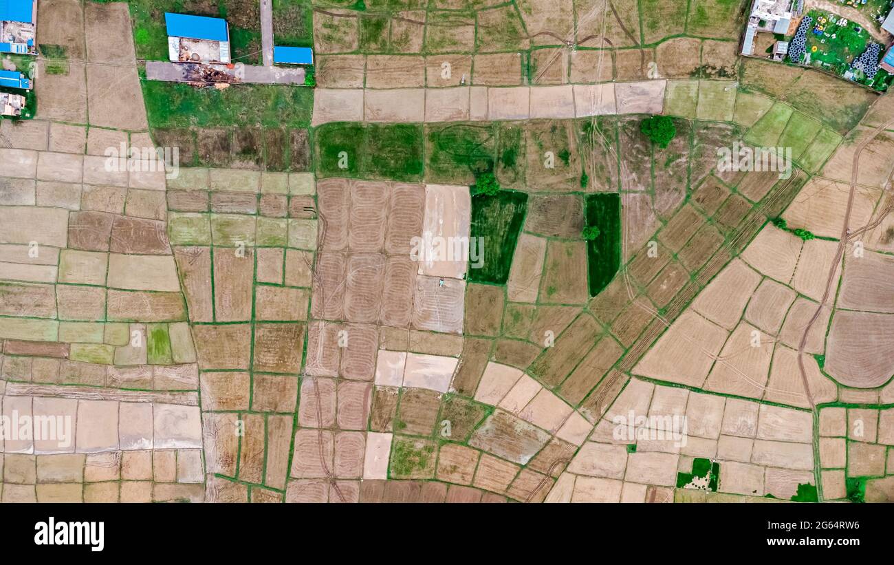 Aerial view of fresh cultivated land. Farmlands divided into rectangular block aerial shot. Monsoon season in Nepal. Stock Photo