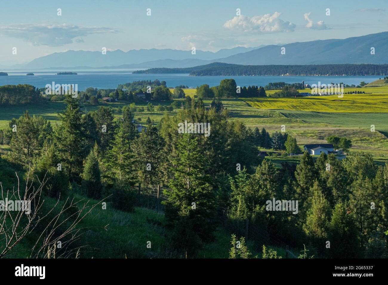 The southern edge of Flathead Lake near Polson, Montana is seen from an overlook with fields of