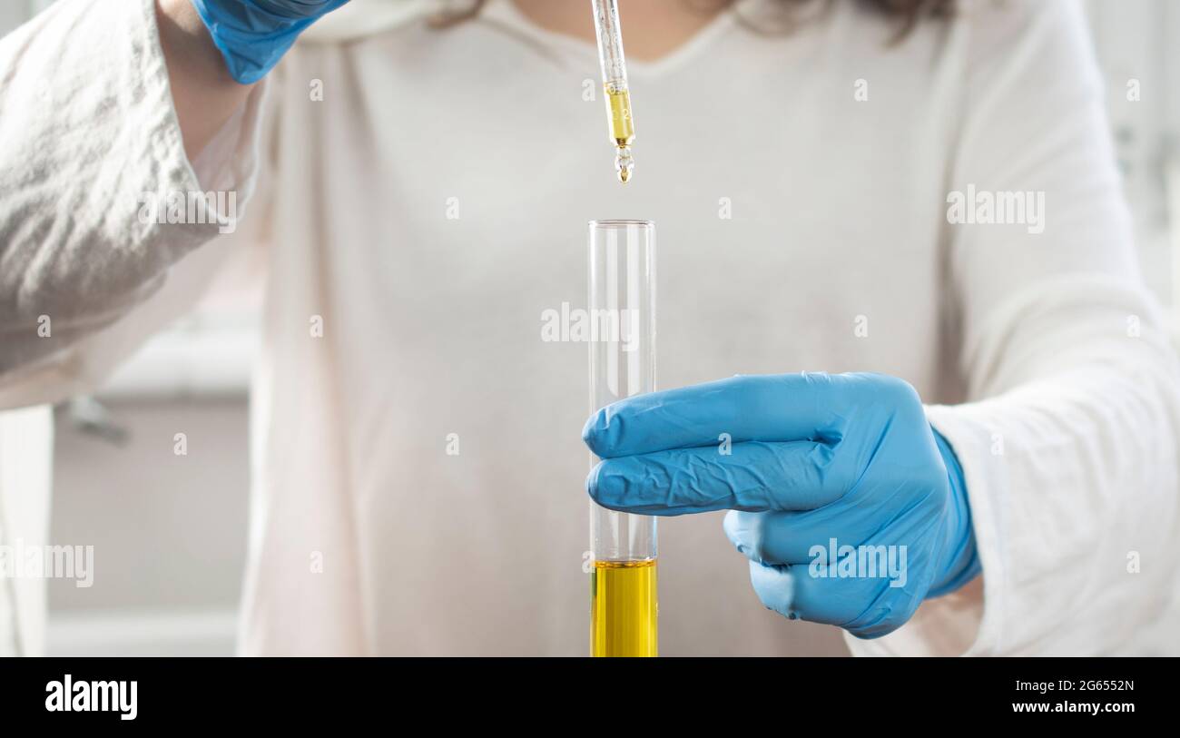 Clean and sterile gloved person dropping solution with a dropper