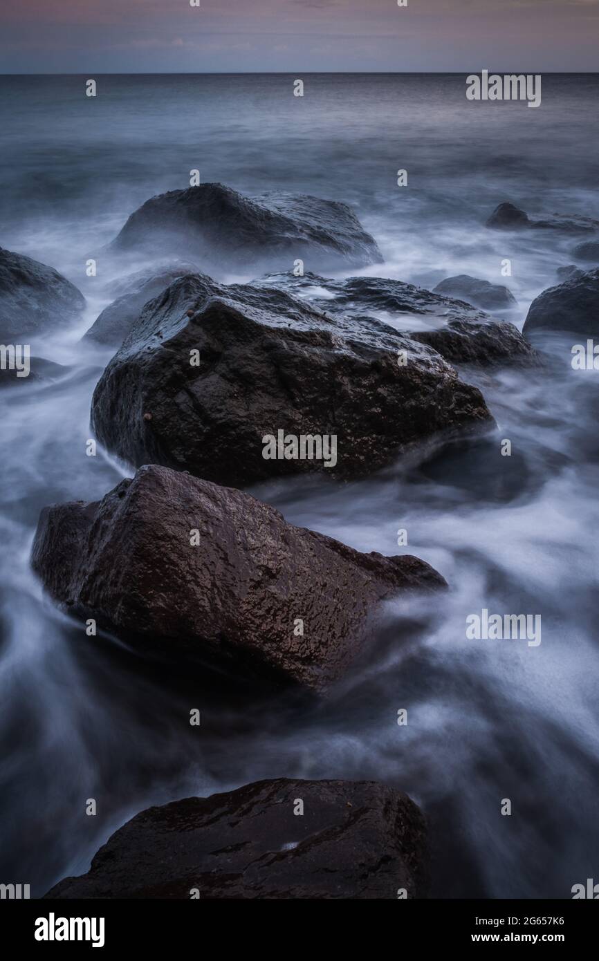 Rocks and flowing waves Stock Photo - Alamy