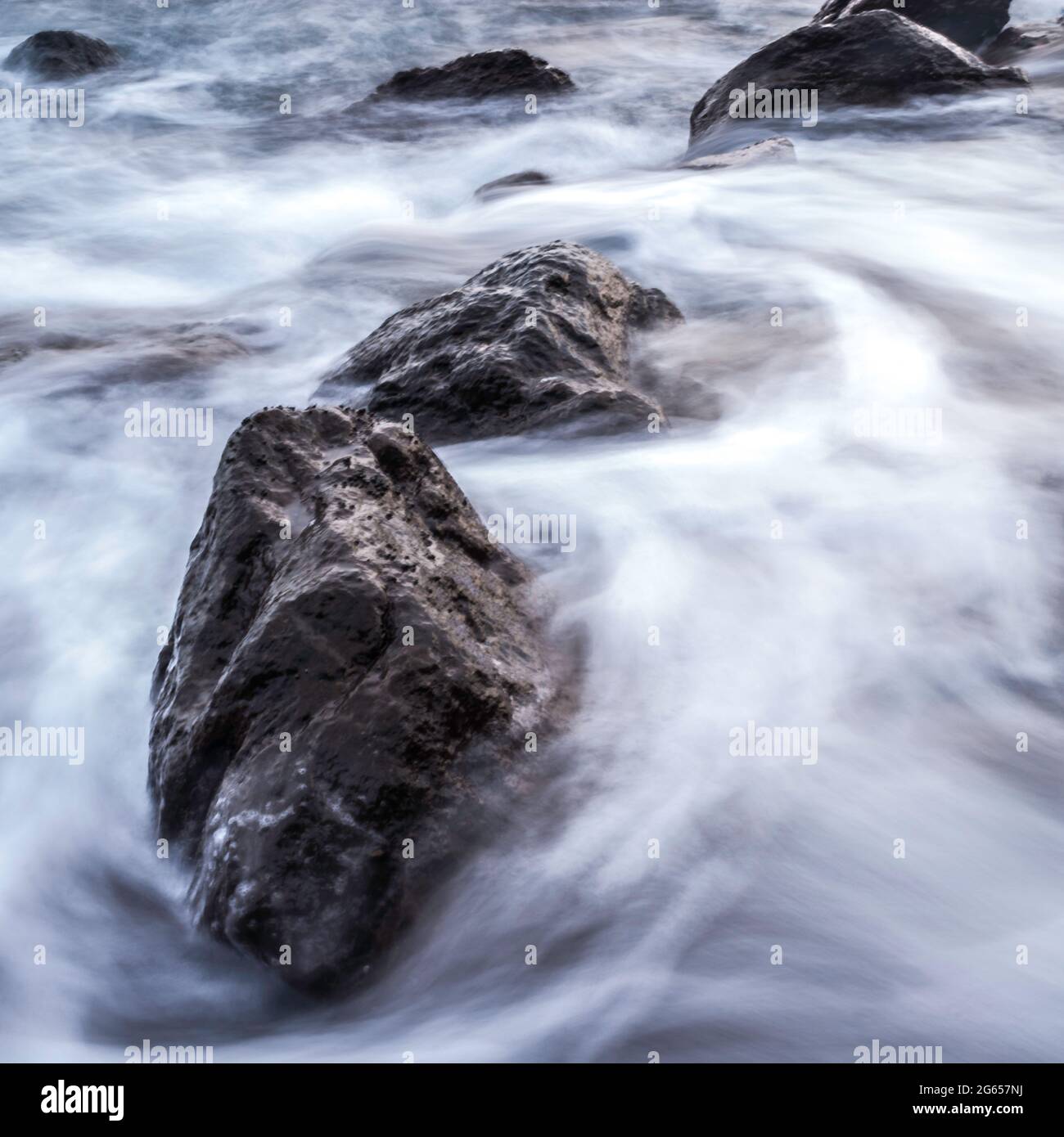 Rocks and flowing waves Stock Photo - Alamy