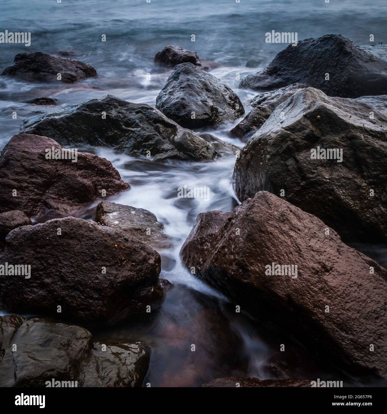 Rocks and flowing waves Stock Photo - Alamy