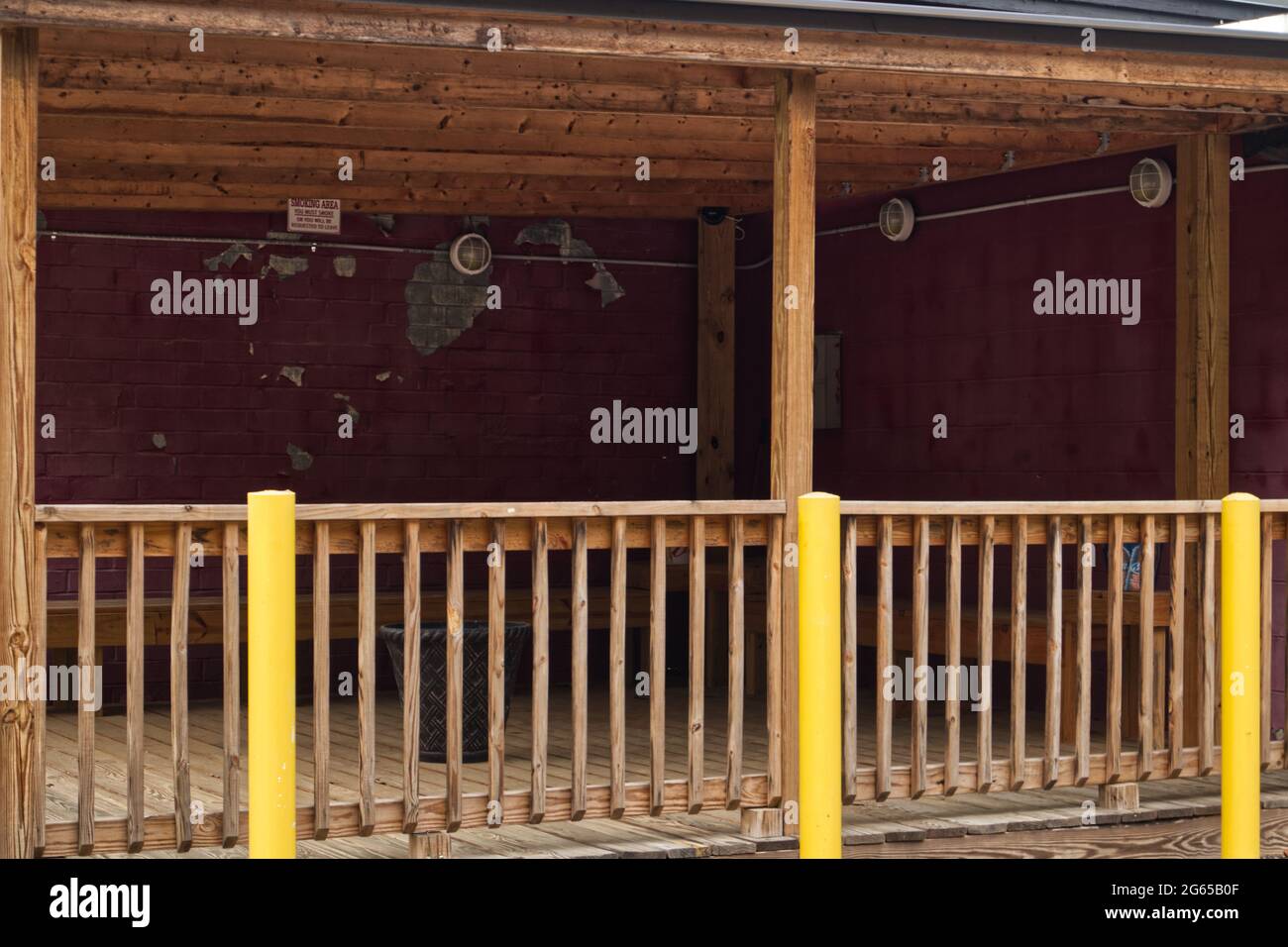 Smoking Area Rails A patio smoking area with wooden rails and vintage decor peeling paint ...