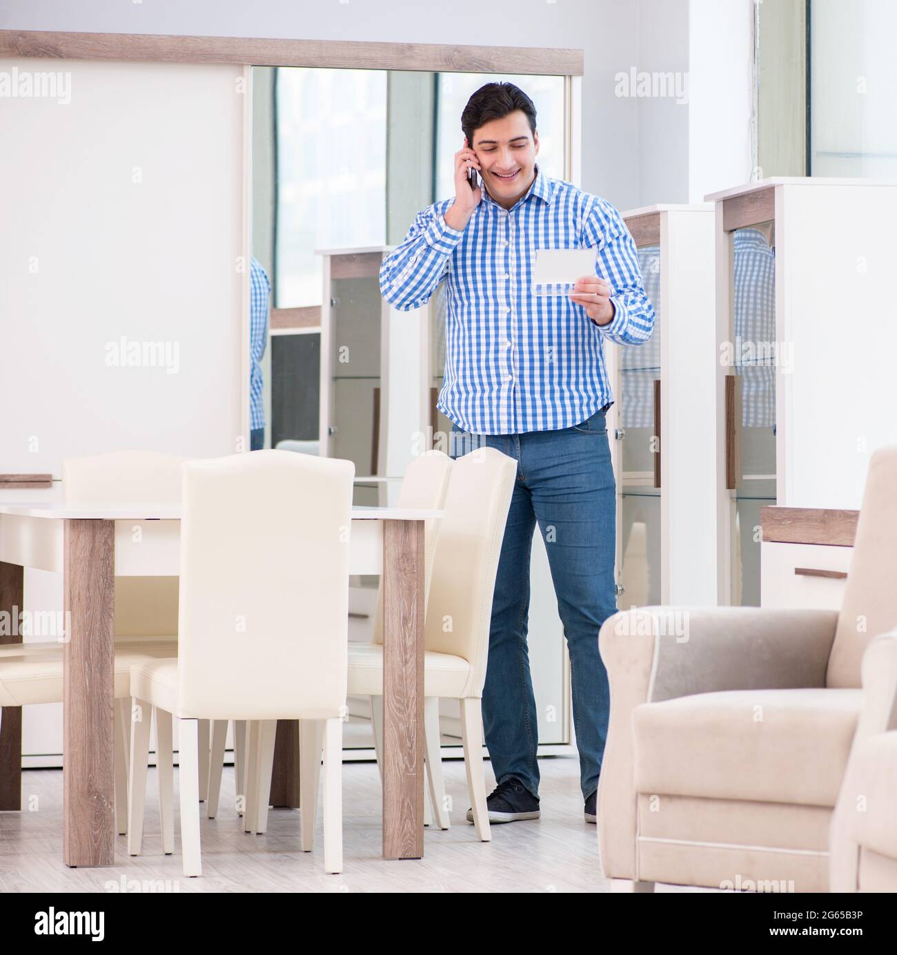 The young man shopping in furniture store Stock Photo - Alamy