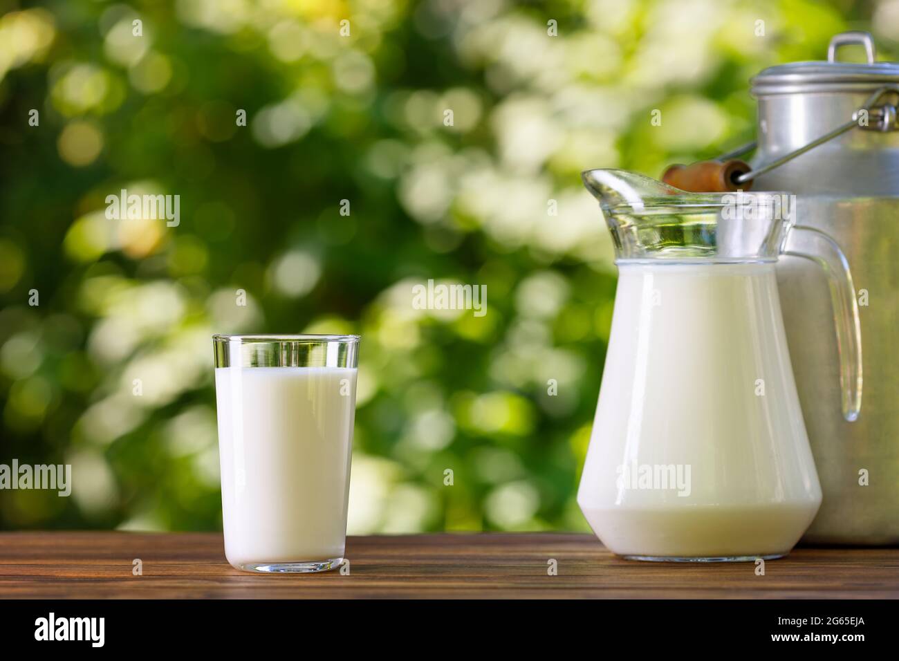 milk in glass and jug with metal can Stock Photo