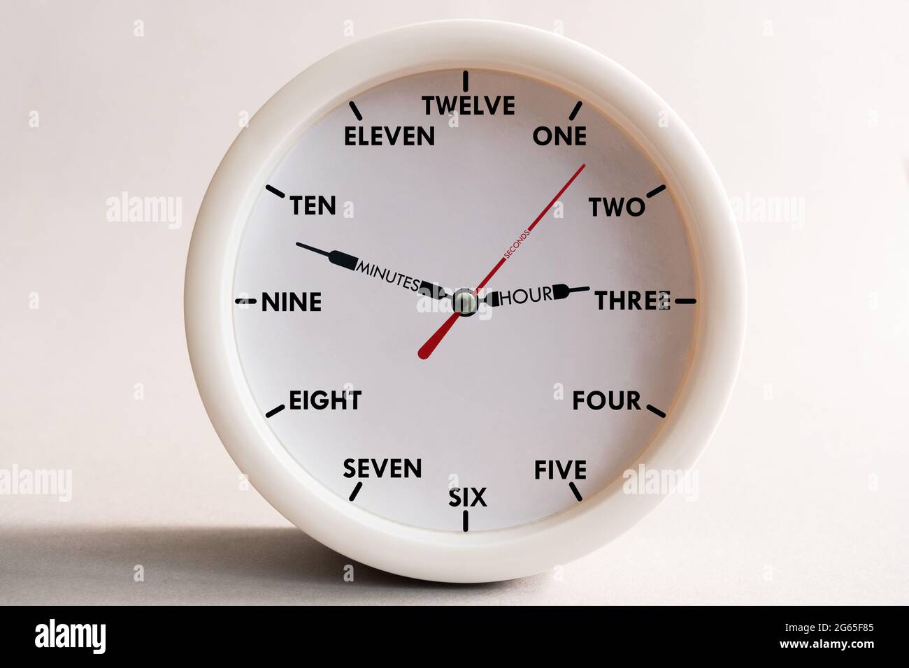 Hour dial with numbers spelled out in words for teaching children to count, language and time orientation by the clock. Stock Photo