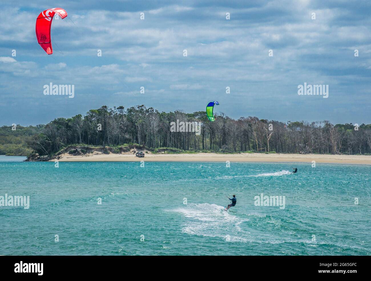 kiteboarders are pulled across water by power kites at Sandy Cove in the estuary of the Noosa River at Noosa Heads, Sunshine Coast, Queensland, Austra Stock Photo
