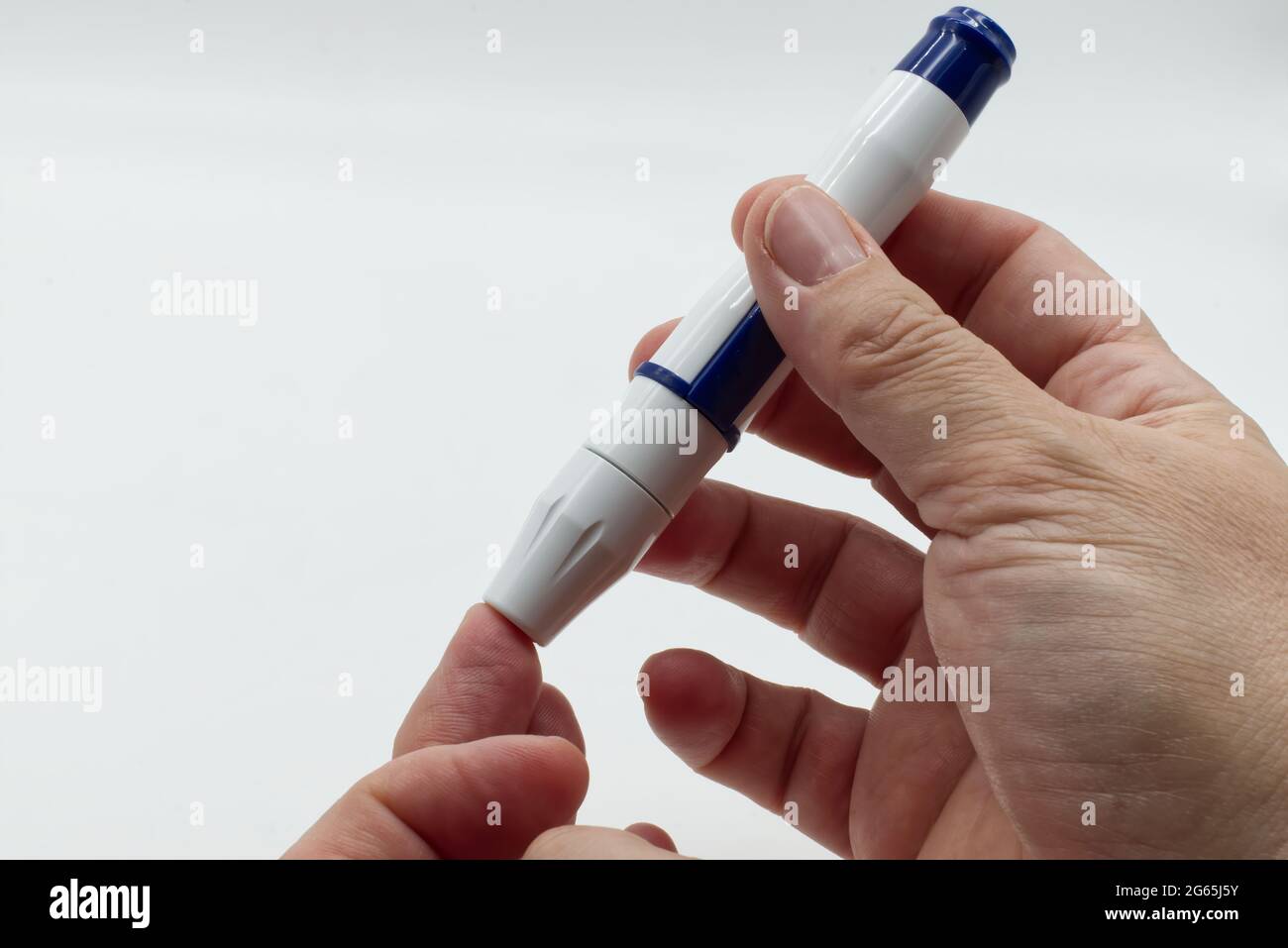 Woman with diabetes using lancet pen before using isolated