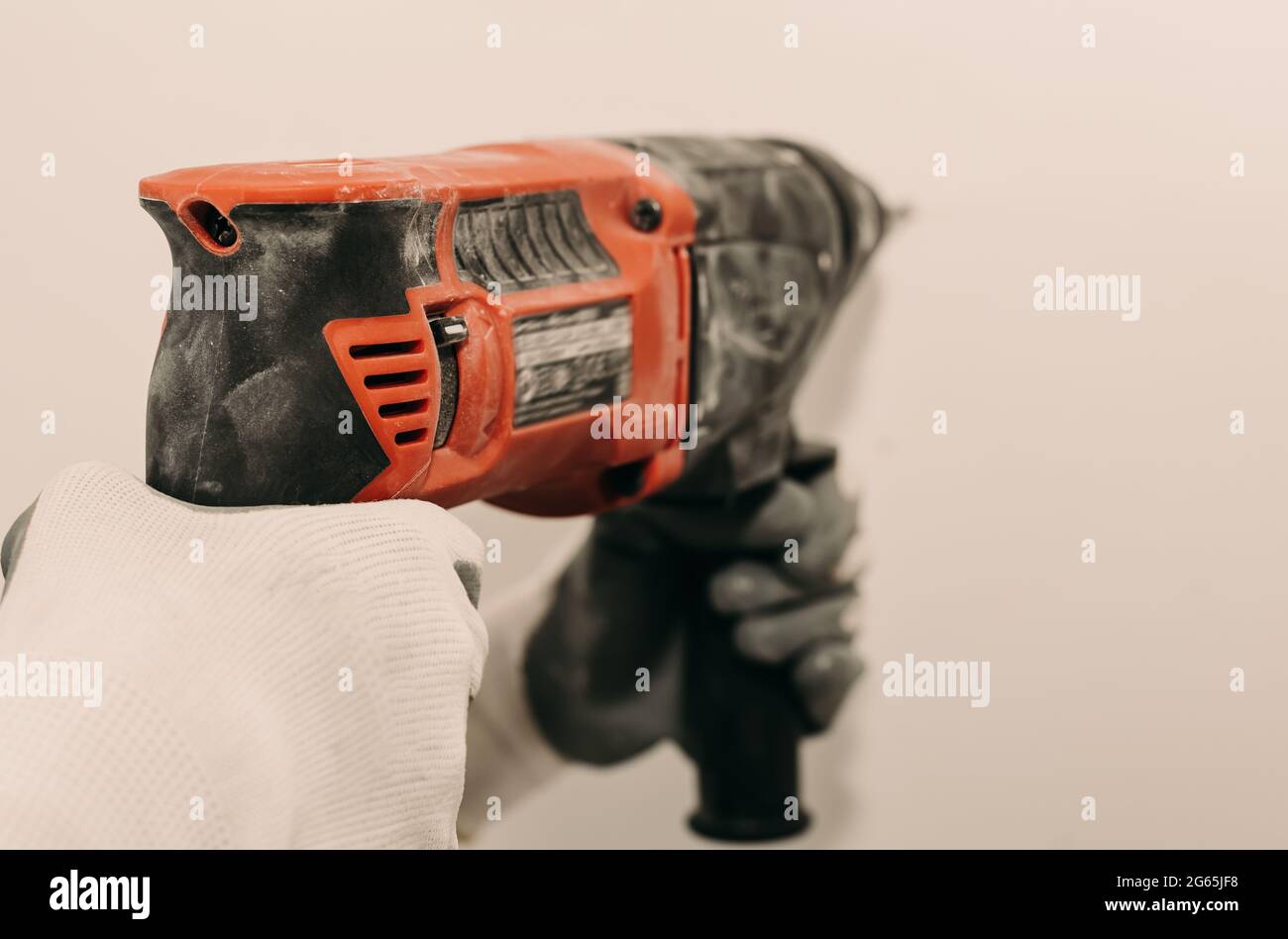 Electric drill. Power tools. The hand uses a drill to drill a hole in the wall. Repair. Construction Stock Photo
