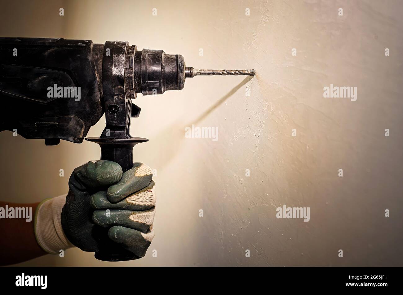 Electric drill. Power tools. The hand uses a drill to drill a hole in the wall. Repair