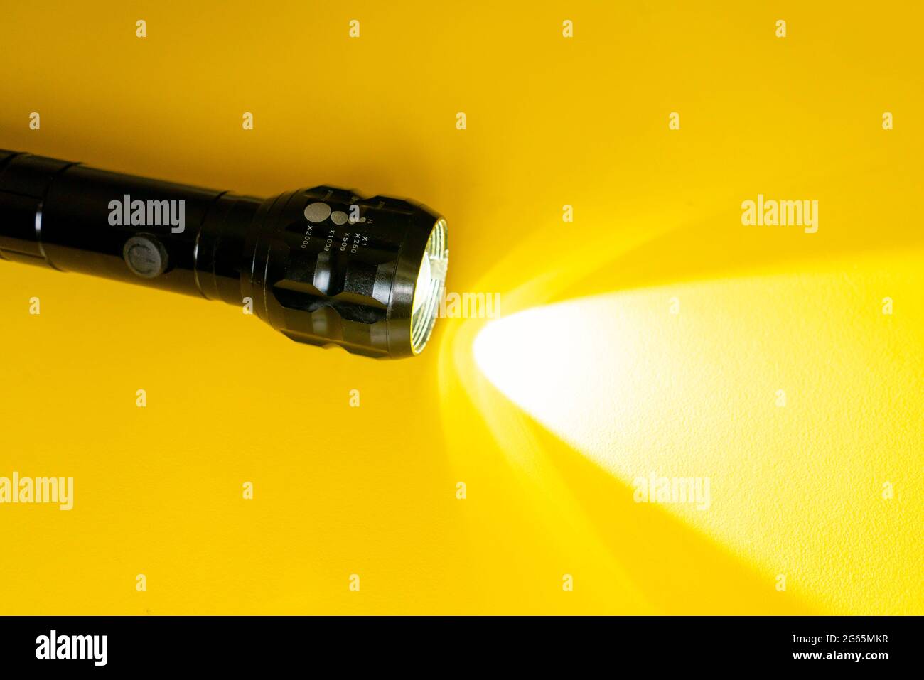 steel torch isolated on yellow surface, producing light beams or rays