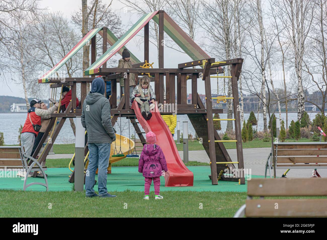 Belarus, Minsk - April 17, 2021: Parents with children without masks play in the playground and do not observe social distance. Stock photography. Stock Photo