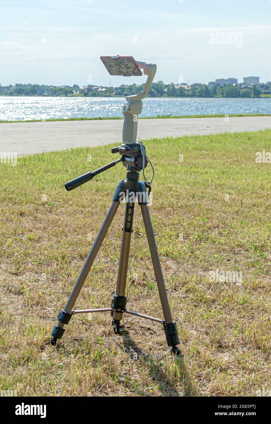 smartphone is mounted on a studicam and mounted on a tripod, a blurry background with bokeh elements. Stock photo. Stock Photo