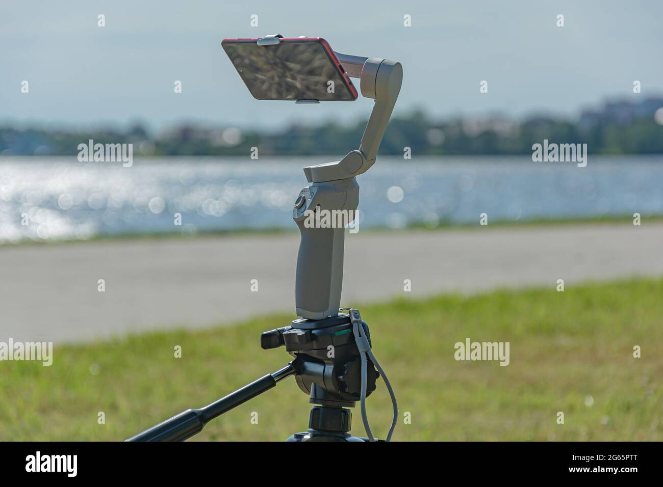 smartphone is mounted on a studicam and mounted on a tripod, a blurry background with bokeh elements. Stock photo. Stock Photo