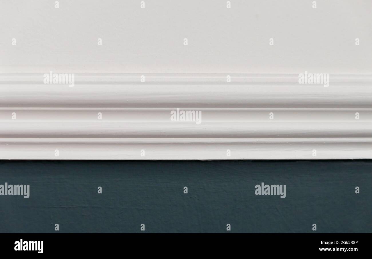 Close up of white dado rail with white above and teal blue green below Stock Photo