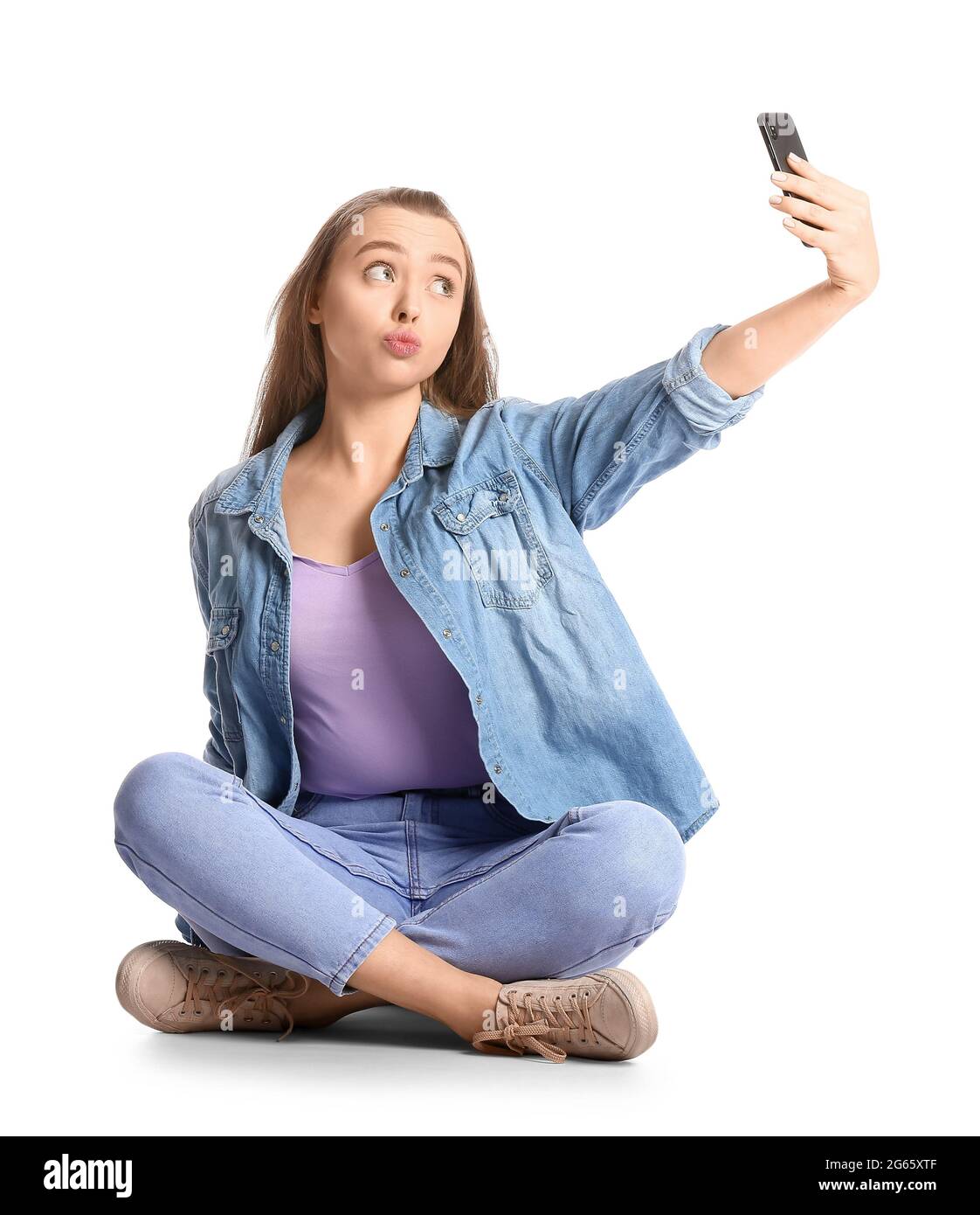 Beautiful young woman taking selfie on white background Stock Photo - Alamy