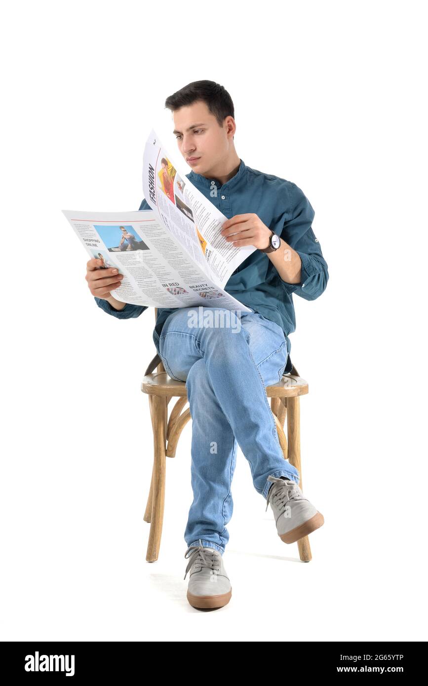 Young man reading newspaper on white background Stock Photo