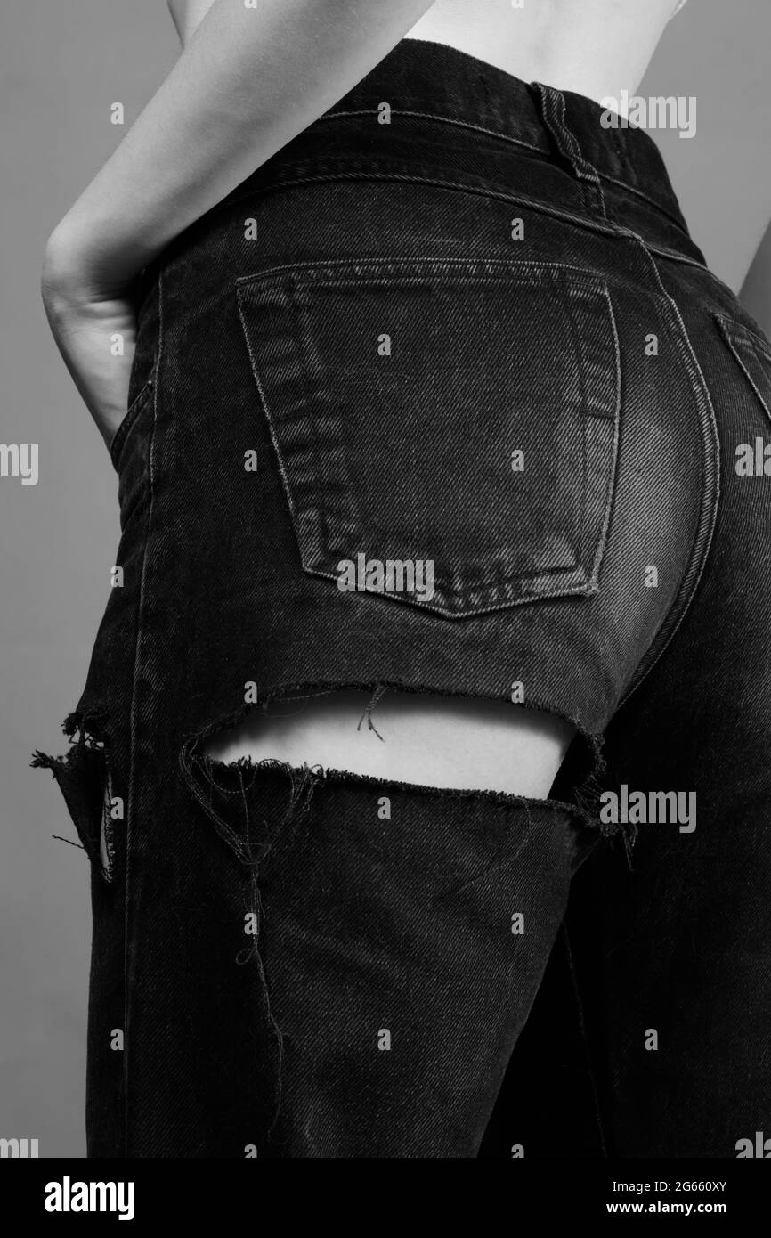 beautiful slim female back in ripped jeans close up, monochrome Stock Photo