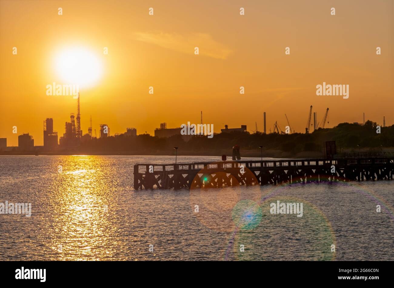 Old wooden pier in front of port silhouettes in Antwerp. Stock Photo