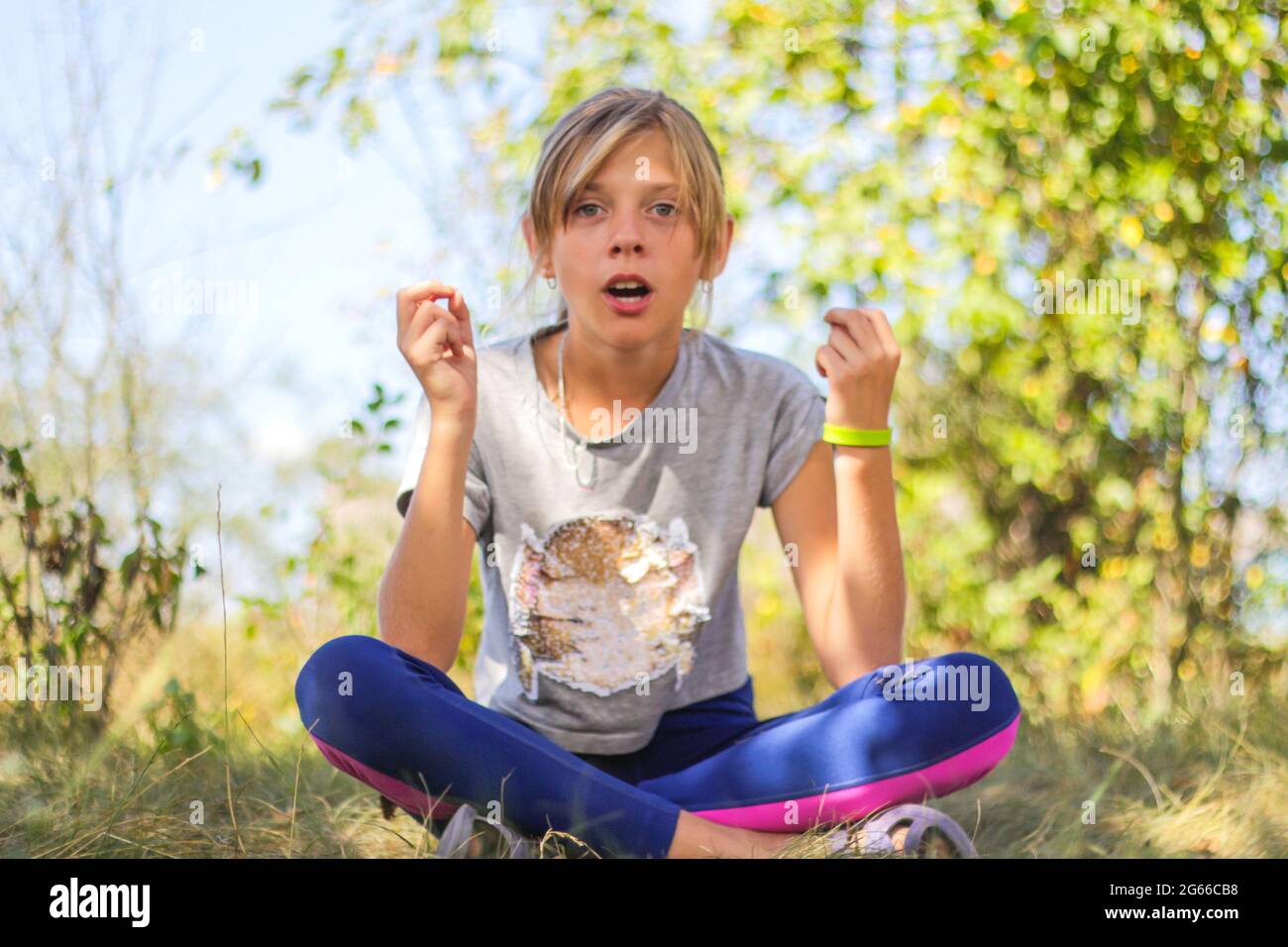 Defocus caucasian preteen girl practicing yoga in park, forest, outdoor, outside. Meditation, concentration, mantra. Wellness lifestyle. Portrait of g Stock Photo