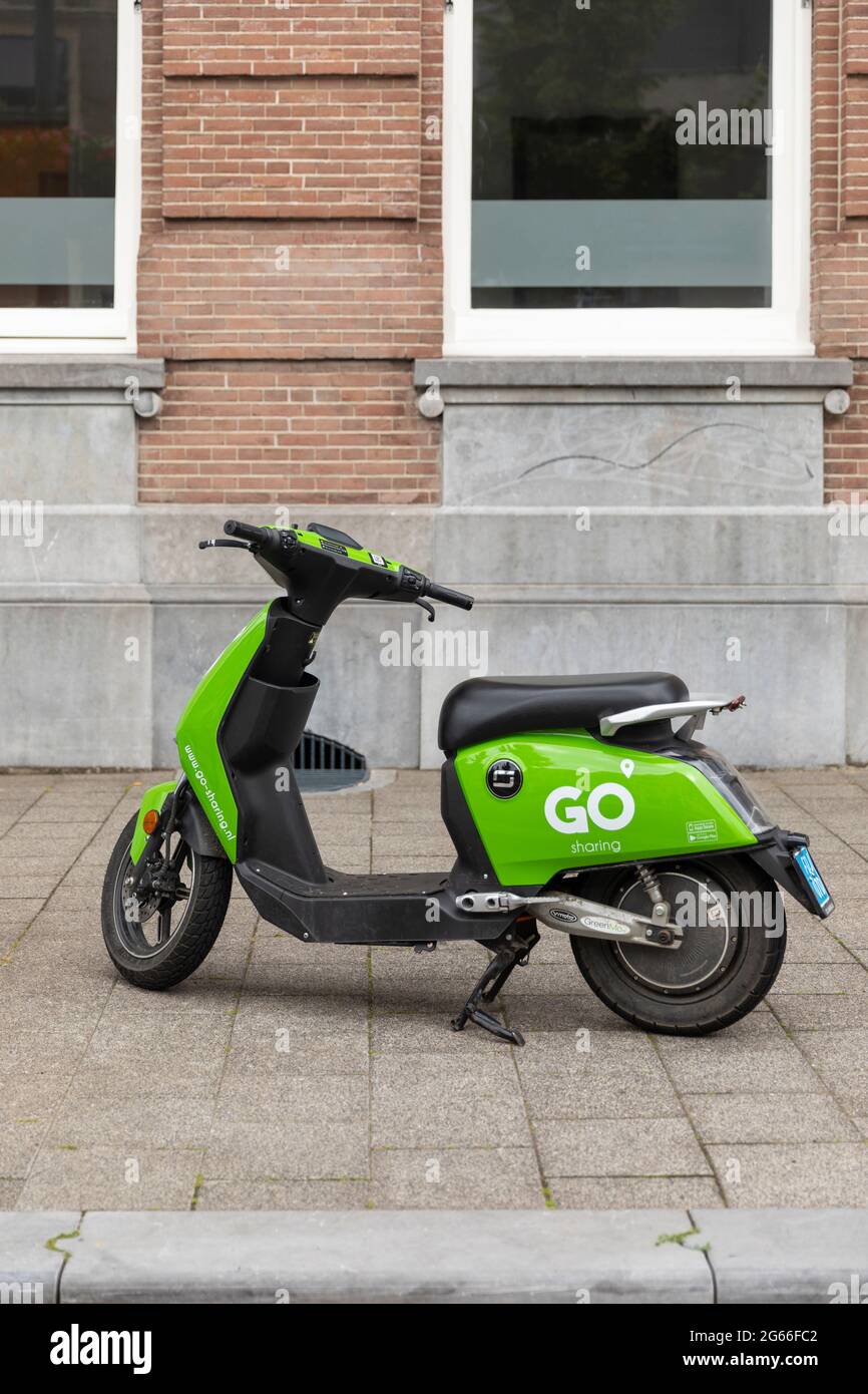 Breda, The Netherlands June 28th 2021. Sharing economy electric green  scooter, parked on a sidewalk in the city, waiting to be rented and used  through Stock Photo - Alamy