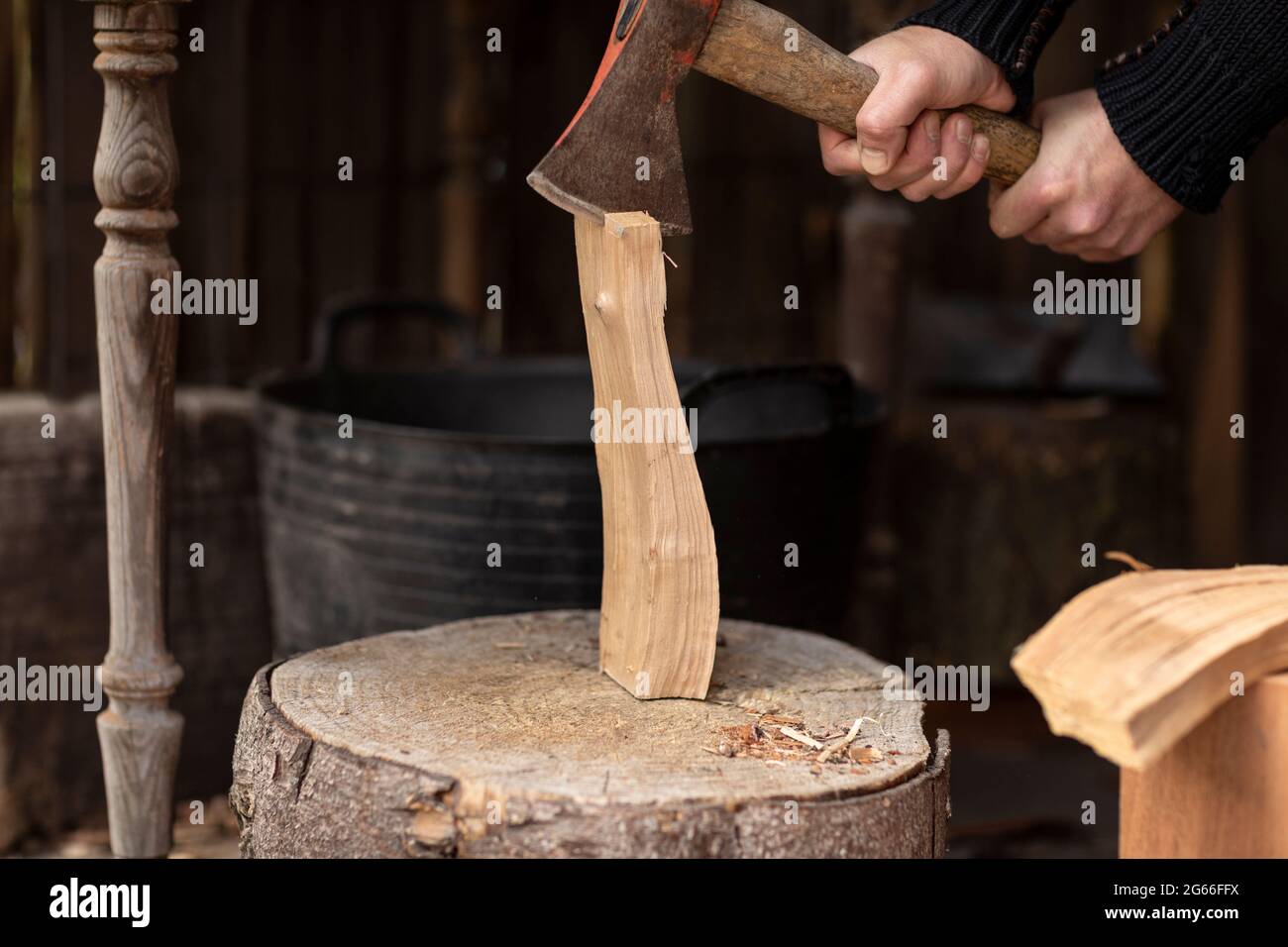 Lumberjack Splitting A Log Of Firewood With An Old Axe On A Big Wooden