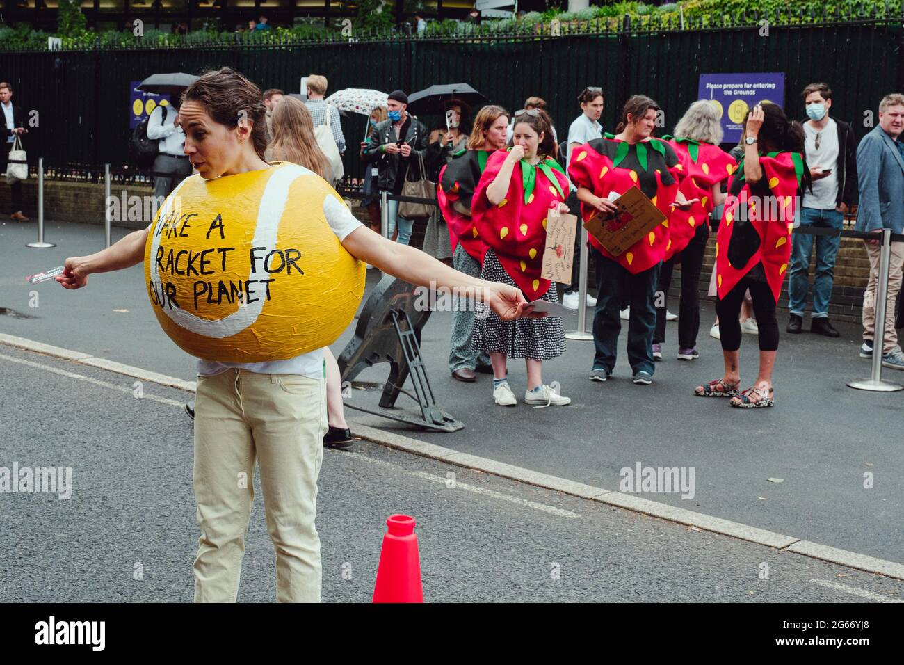 London, UK. 2nd July, 2021. A group of activists with giant tennis balls, rackets, headbands and tennis gear and suited as bankers protest outside the Wimbledon arena this year's Wimbledon tournament is sponsored by HSBC, who are responsible for funding £81bn-worth of fossil fuels since the Paris Climate Agreement of 2015. Credit: João Daniel Pereira Stock Photo