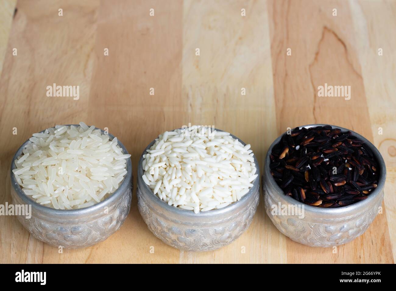 Three types of Thai rice in a silver container. On wood background and ...