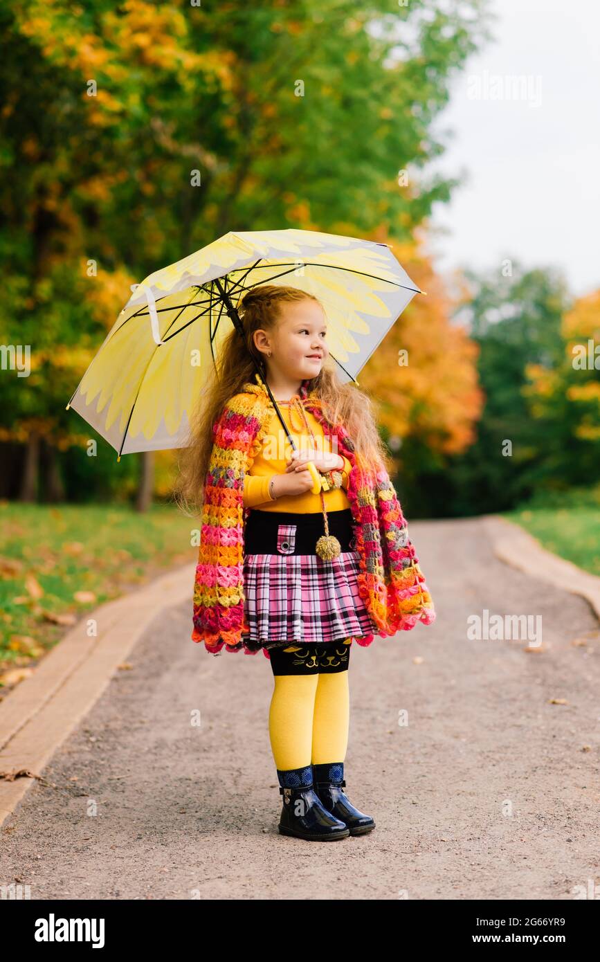 Smiling little girl with umbrella in a raincoat and boots outdoor Stock Photo Alamy
