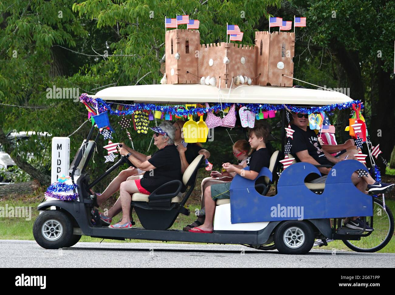 Sullivans Island, South Carolina, USA. 3rd July, 2021. A family drives their decorated golf cart during the annual Bicycle and Golf cart parade celebrating Independence Day July 3, 2021 in Sullivans Island, South Carolina. Credit: Planetpix/Alamy Live News Stock Photo