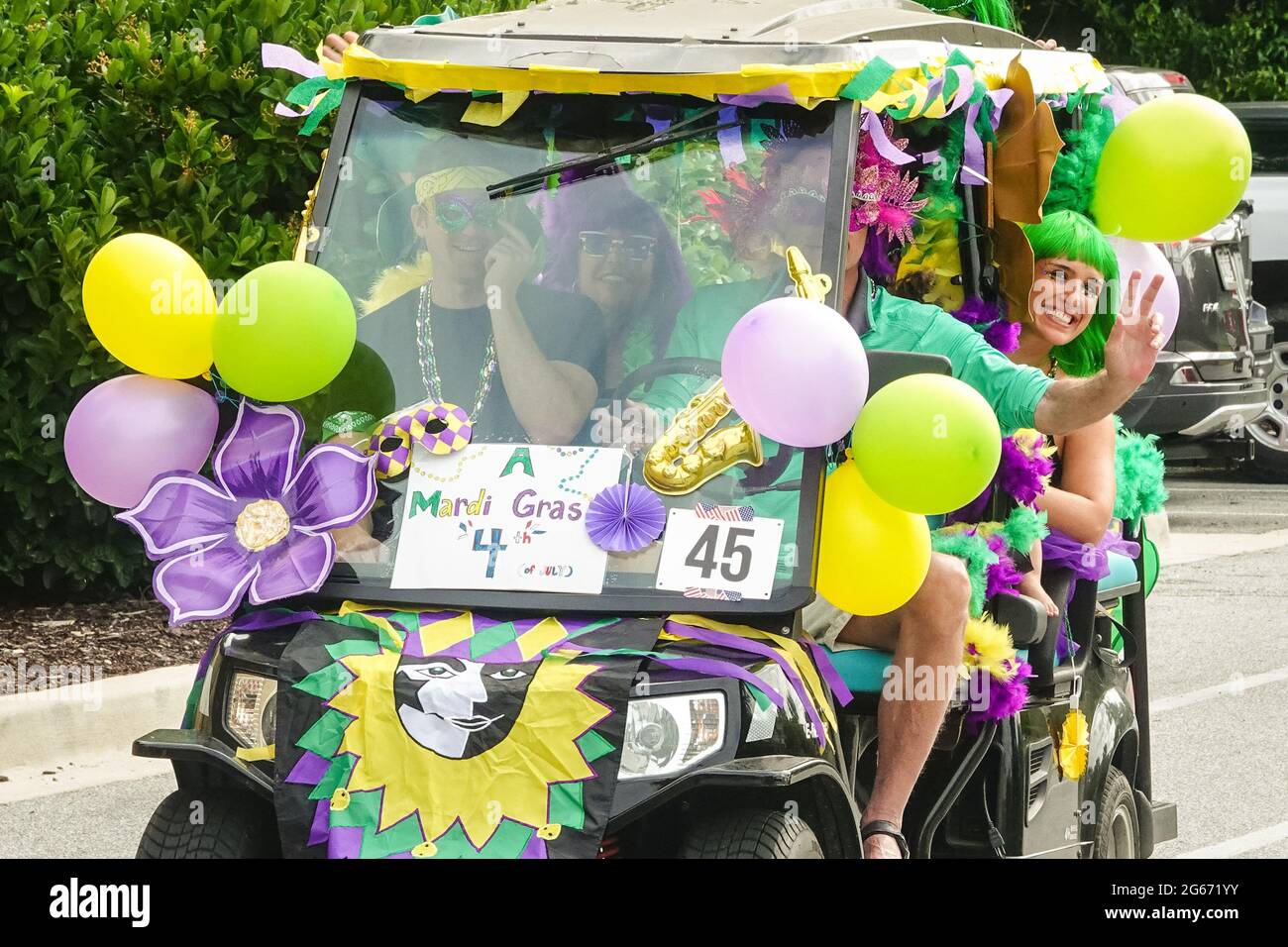 Sullivans Island, South Carolina, USA. 3rd July, 2021. A family drives their golf cart decorated in a Mardi Gras theme during the annual Bicycle and Golf cart parade celebrating Independence Day July 3, 2021 in Sullivans Island, South Carolina. Credit: Planetpix/Alamy Live News Stock Photo