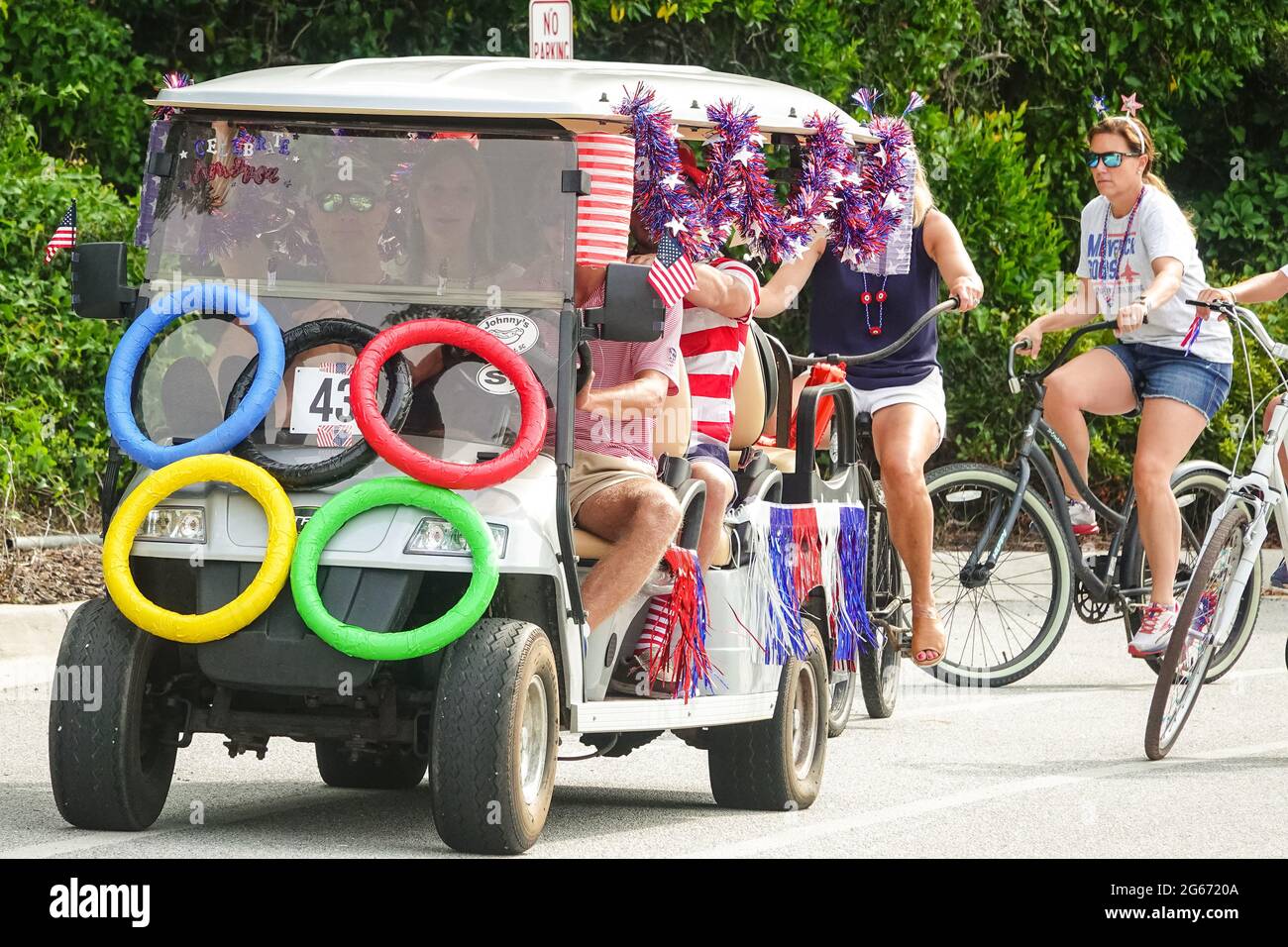 Sullivans Island, South Carolina, USA. 3rd July, 2021. A family drives their golf cart decorated in the Olympic Games theme during the annual Bicycle and Golf cart parade celebrating Independence Day July 3, 2021 in Sullivans Island, South Carolina. Credit: Planetpix/Alamy Live News Stock Photo