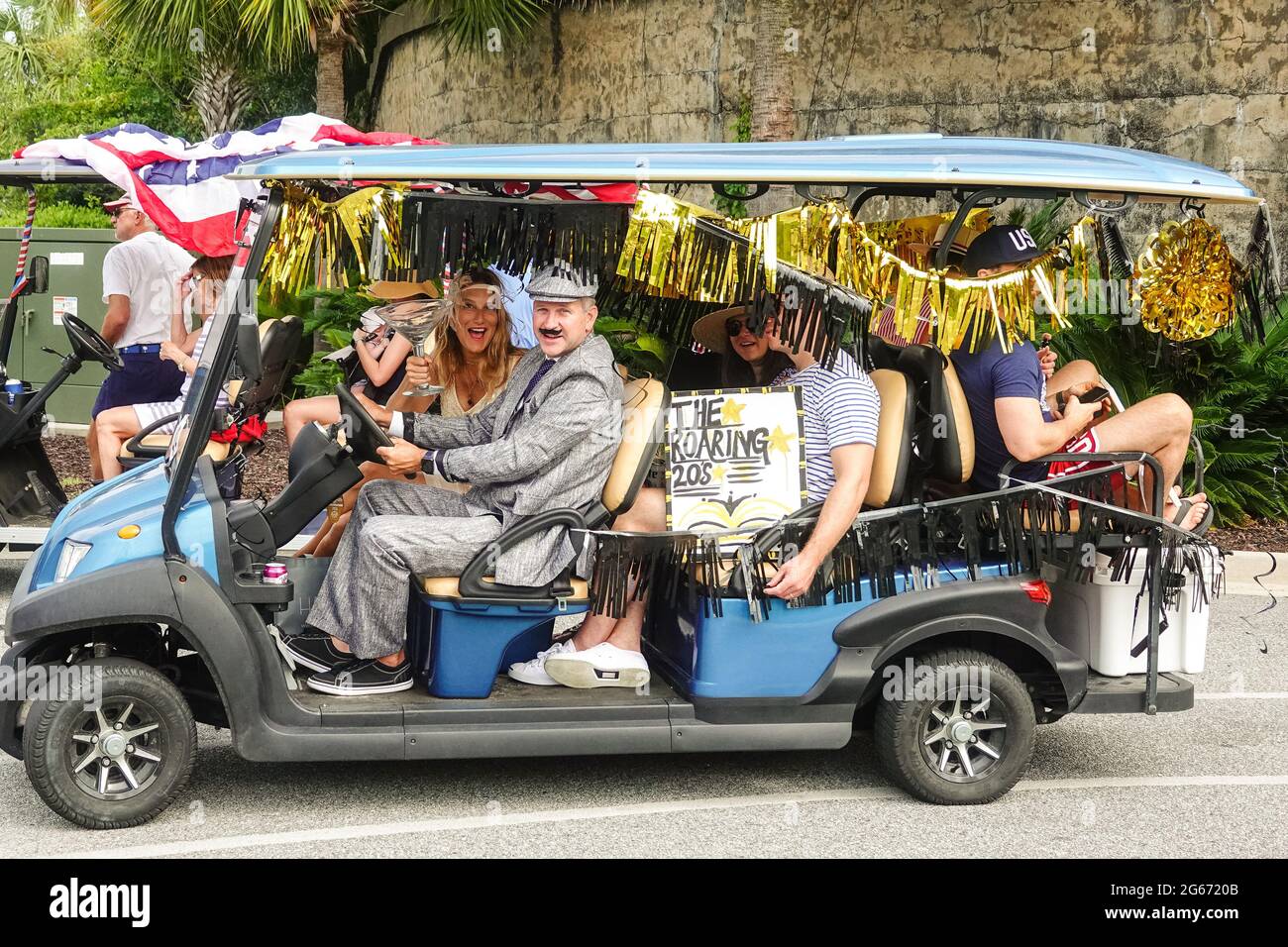 Sullivans Island, South Carolina, USA. 3rd July, 2021. A family drives their golf cart decorated in a Roaring Twenties theme during the annual Bicycle and Golf cart parade celebrating Independence Day July 3, 2021 in Sullivans Island, South Carolina. Credit: Planetpix/Alamy Live News Stock Photo