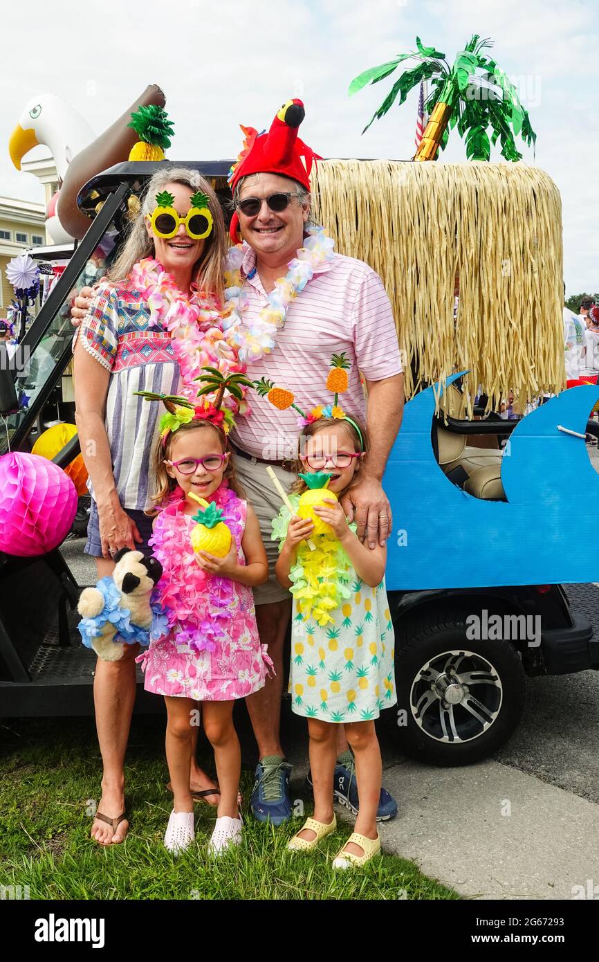Sullivans Island, South Carolina, USA. 3rd July, 2021. A family wearing Tiki costumes pose by their decorated golf cart during the annual Bicycle and Golf cart parade celebrating Independence Day July 3, 2021 in Sullivans Island, South Carolina. Credit: Planetpix/Alamy Live News Stock Photo
