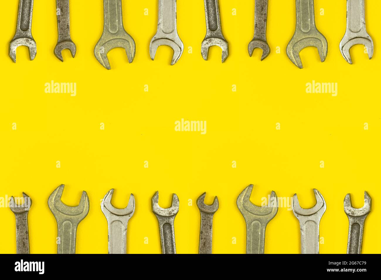 Various wrench tools border backround, yellow worker table workspace concept, top view and copy space Stock Photo